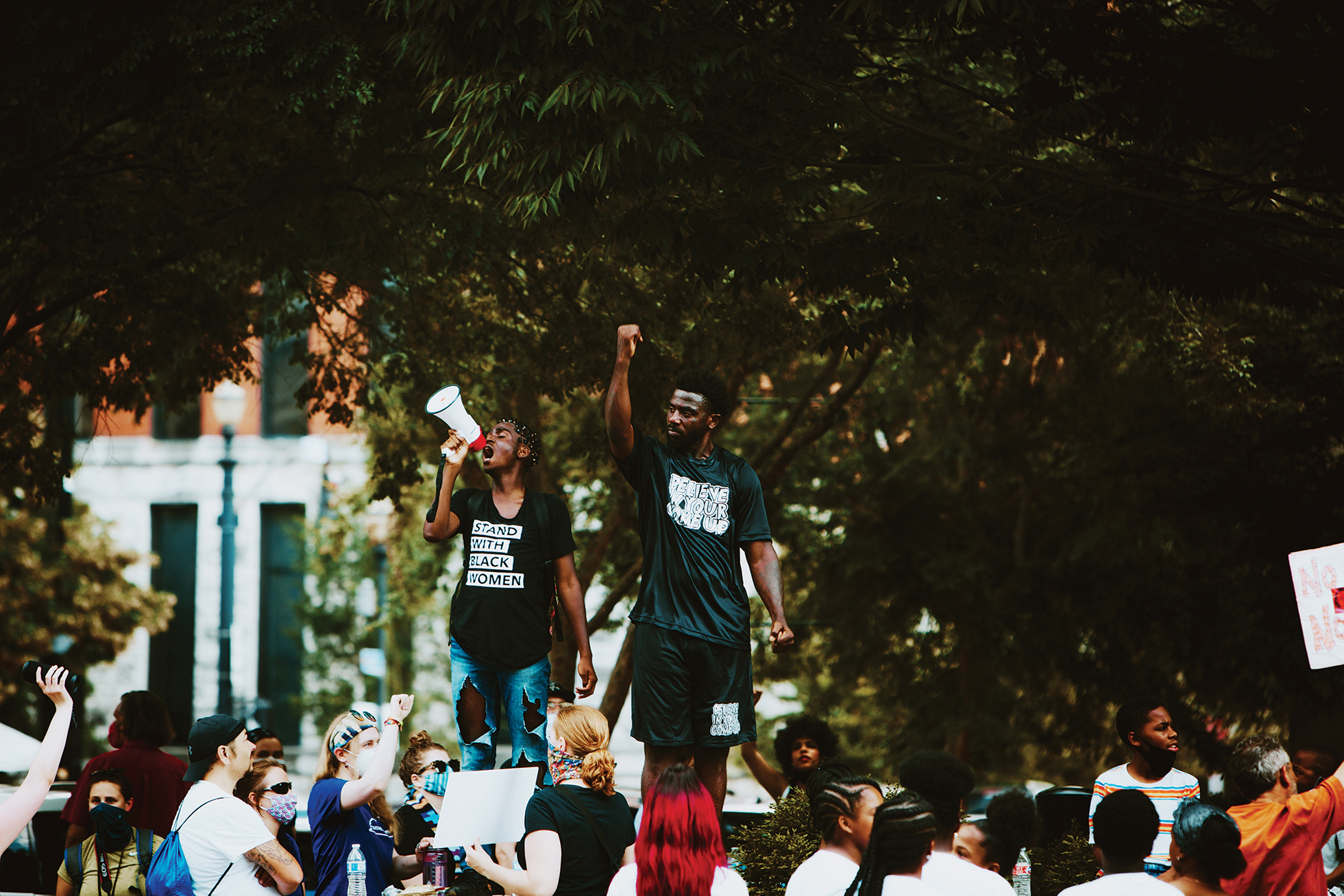 Two figures lead a crowd of protesters.