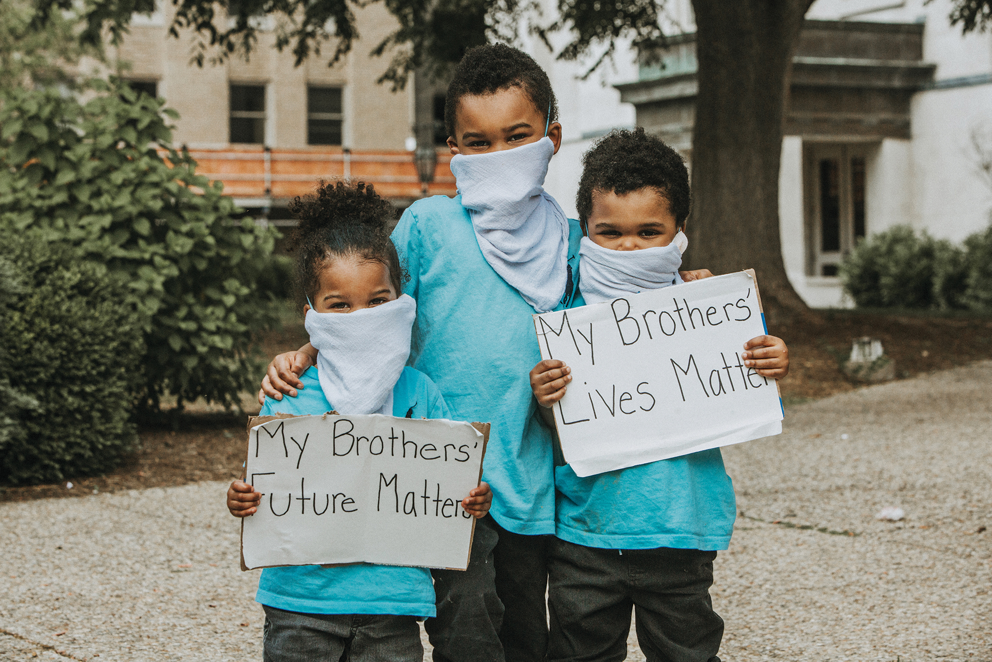 Three young boys holding signs that read "My Brothers' Lives Matter" and "My Brothers' Future Matters."