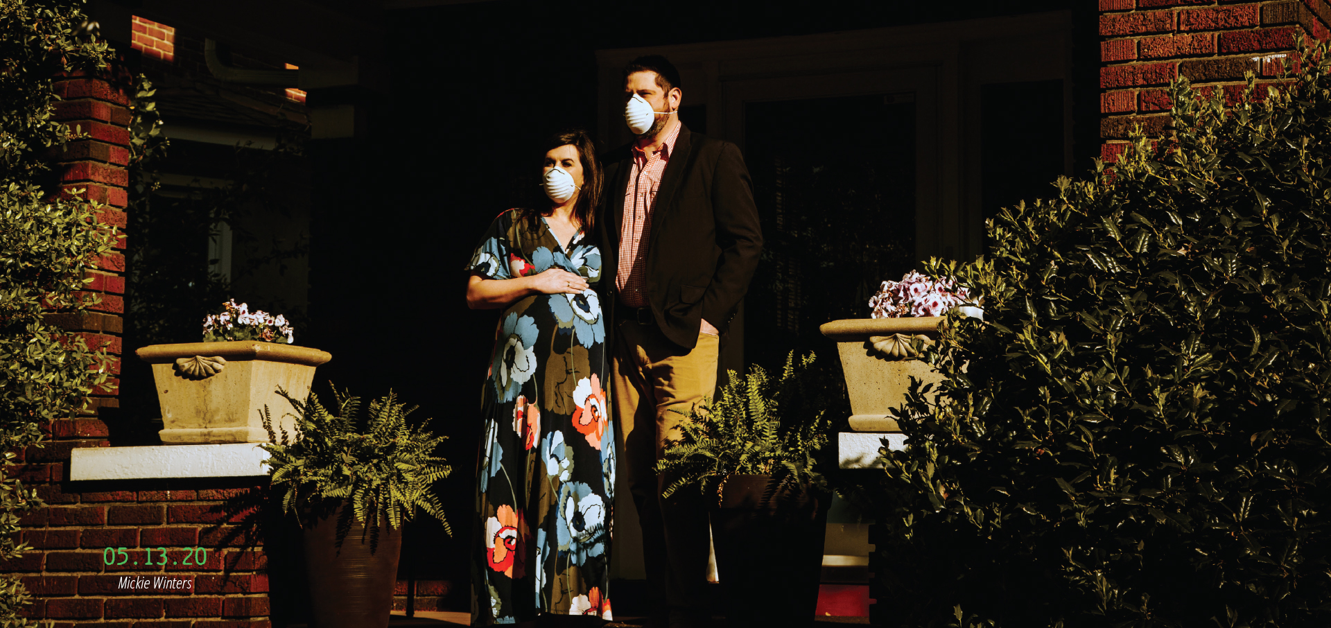 A pregnant couple standing on their porch wearing masks. 05.13.20, by Mickie Winters